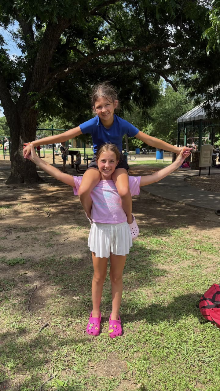 Two campers smiling at the camera on the grass at Camp Little Willow